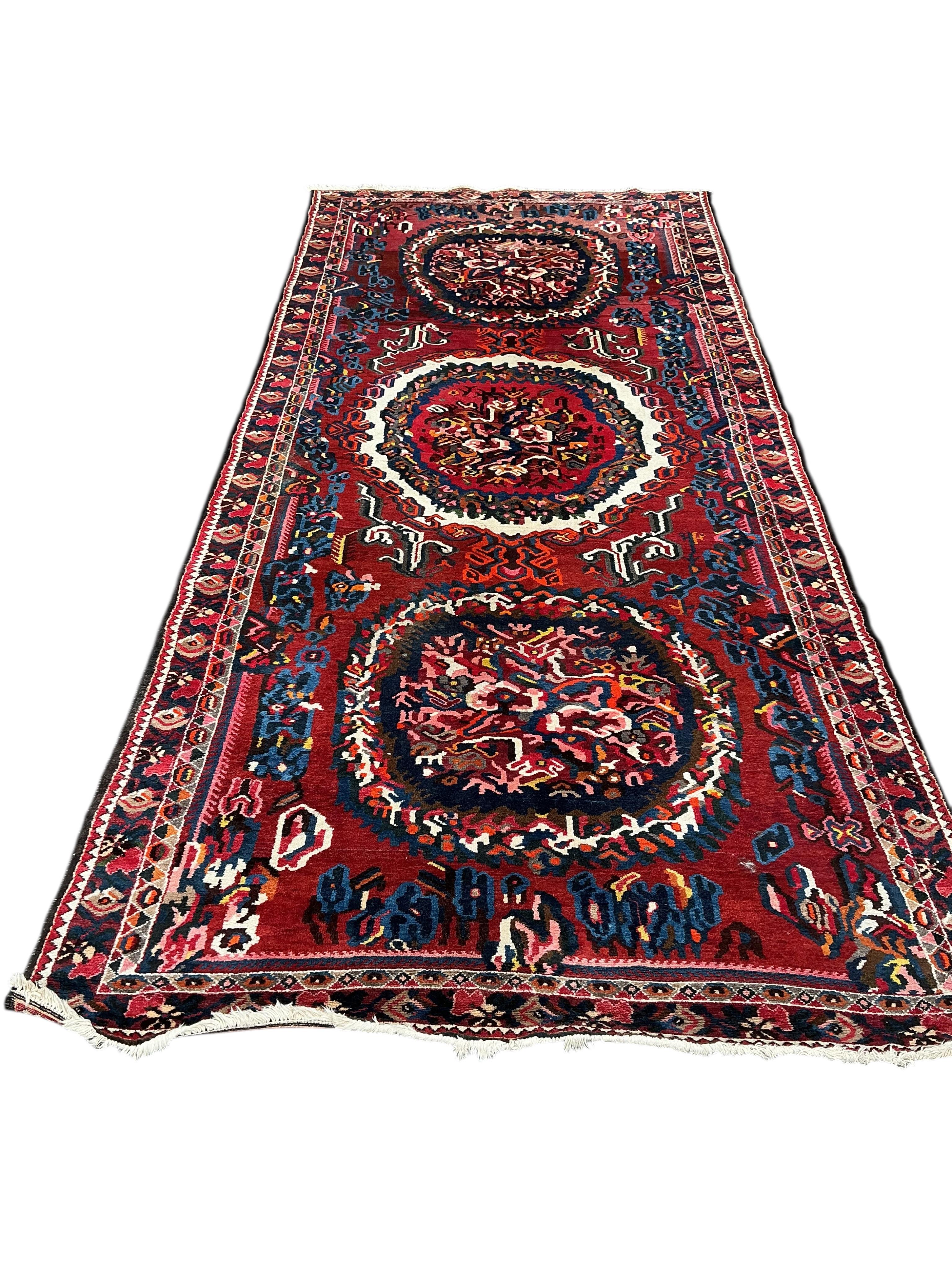 A Baktiari red ground carpet, 390 x 170cm